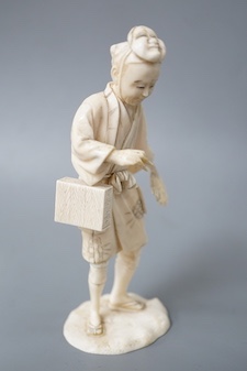 A Japanese carved ivory figure, Meiji period, of an actor, having a noh mask on the crown of his head and holding a fan, incised signature to base, height 16cm